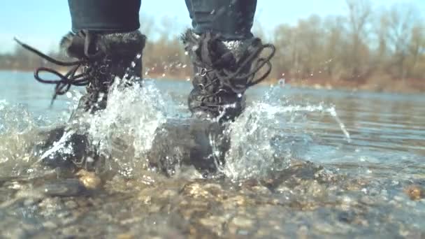 慢动作 亲密快乐的女孩在浅水湖中踩踏着脚 并向周围泼洒着晶莹的水 顽皮的女人在平静的河里跳跃 难以辨认的女性享受秋天的快乐 — 图库视频影像
