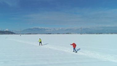 Hava: Mükemmel bir kış gününde, güneşli ve huzurlu kırsalda kayak yapan tanınmayan iki kadın. Görkemli Slovenya 'da kayak yapan aktif kadın turistleri çevreleyen resim gibi dağlar.
