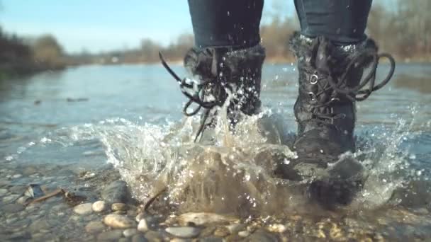 慢动作 特写镜头 难以辨认的顽皮女人在平静溪流的浅水中跳跃 快乐的女孩 用她的脚在清澈的池塘里欢快地泼水 — 图库视频影像