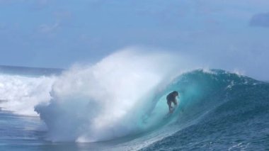 Slow Motion, Close Up: Extreme sörfçüsü Fransız Polinezyası 'nda güneşli bir günde mükemmel camdan bir okyanus dalgası sürüyor. Tahiti kıyılarında büyük bir zümrüt dalgasıyla sörf yapan profesyonel sörfçünün nefes kesici görüntüsü..