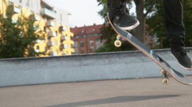 Slow Motion Close: Tanınmayan genç kaykaycı adam beton parka mükemmel bir tekme attı. Havalı patenci güneşli bir günde şehirde eğleniyor. Sinematik kaykay
