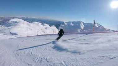 Takip edin: Parlak kış güneşi Slovenya'da pitoresk bir kayak merkeziboş bir yamaç aşağı snowboard kadın parlar. Binici dağların muhteşem bir görünümü ile bir parça aşağı onu snowboard hızları.