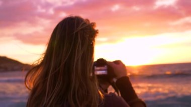 Yaklaş, Lens Flare: Bilinmeyen kadın okyanusun fotoğraflarını çekiyor ve rüzgarlı bir akşamda güzel bir yaz günbatımı. Yaz tatilinde tanınmayan bir kız kamerasıyla gün doğumunu ve dalgaları yakalıyor..