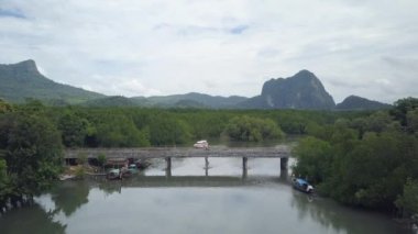 Hava tembel bir tropikal nehir geçerken küçük bir beton köprü doğru uçan. El değmemiş yağmur ormanları ve trafik geçen adam köprü yapılmış sonsuz bir açıklıktan akan kanal muhteşem atış