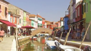 Burano İtalya, Haziran 2017: Tatilde turistler pitoresk Burano güzel bir sokakta yürüyüş, İtalya. Gezginlerin kalabalığı doğal Venedik kanalına bakıyor ve sakin bir barda oturuyor..