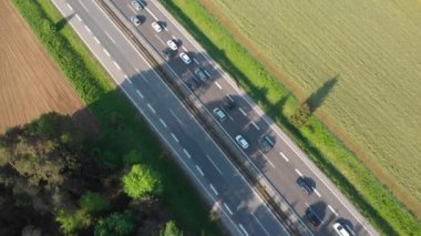 Hava: Yoğun trafik yavaş yavaş güneşli yeşil doğada beton karayolu boyunca hareket ediyor. Araba ve kamyon üzerinde uçan yaz sezonunda kötü bir tıkanıklık içinde sıkışmış alıyorum. Yolcular ve turistler
