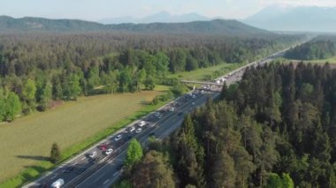 Hava: İşten eve giden yolcular, yoğun saatlerde yoğun otobanda trafik sıkışıklığına takılıp kalıyorlar. Tatil için deniz kenarına ulaşmaya çalışan turistlerle dolu hareketli bir otoyol boyunca uçmak