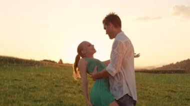 Slow Motion, Close Up, Lens Flare: Genç erkek dansçı kız arkadaşını batırır ve yağmurda onu öper. Güzel Kafkas çift sessiz bir yağmurlu akşam pitoresk kırsal ortamda dans ettikten sonra öper