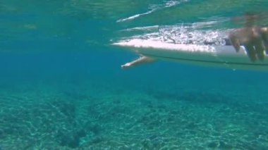 Slow Motion, Close Up, Underwater: Muhteşem Fiji sürme genç sörfçü onun tahta üzerinde yatıyor ve sıraya doğru kürekler. Pro sörfçü epik Cloudbreak dalgalar binmek için kıyıdan uzak kürek
