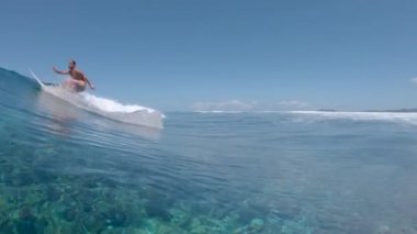 Yavaş Hareket, Düşük Açı, Sualtı: Cool sörfçü mükemmel bir yaz gününde büyük bir Cloudbreak dalga oyma. Pro sporcu mükemmel yaz havasında kristal berraklığında tüp dalga boyunca onun sörf tahtası sürme.