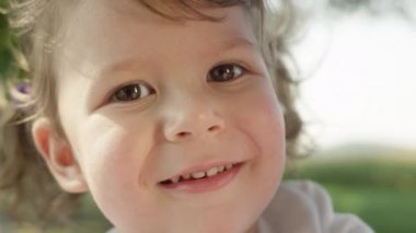 Slow Motion, Portrait, Close Up, Dof: Meraklı küçük Kafkas kız güneşli yaz doğa etrafında bakar. Annesi ve babası ile eğlenceli bir yürüyüş sevimli neşeli küçük kızı parka bakmak için durur.