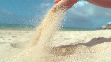 Slow Motion, Close Up: Sayısız beyaz kum taneleri serin yaz esintisinde egzotik plajda tanınmayan bir kadının ellerinden uçup. Cennet adasında geri düşen kum Cool shot.