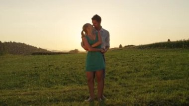 Slow Motion, Lens Flare: Neşeli sarışın kadın, yağmurlu bir akşamda dışarıda dans ederken neşeli erkeğin kucaklaması için zarif bir şekilde kıvrılıyor. Kolay çift yatıştırıcı yaz yağmurda yalınayak dansları.