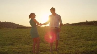Yavaş Hareket, Lens Flare: Güzel yalınayak adam ve kadın çarpıcı yaz gün batımında zarif bir şekilde dans. Neşeli genç çift onlar dans ve romantik bir akşam öpücük gibi yatıştırıcı bahar yağmuru sahiptir.