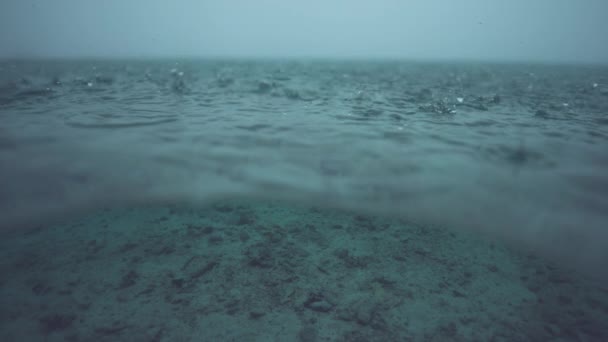 スローモーション ハーフ水中 マクロ Dof 熱帯暴風雨は 穏やかな海の表面に美しいテクスチャを作成します 無限の海に落ちる無数の小さな雨滴の息をのむようなショット — ストック動画
