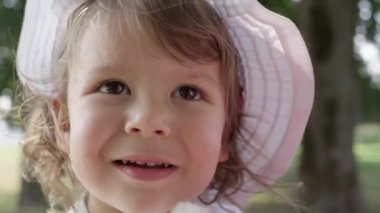 Slow Motion, Close Up, Portrait, Dof: Neşeli küçük kız bebek parkta onu yeni favori oyuncak ile oynar. O onu kabarık oyuncak tavşan ile oynarken güzel gülümseme gülerek güzel yürümeye başlayan.