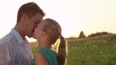 Slow Motion, Close Up, Lens Flare: Güzel sarışın kadın ve güzel bir tarihte yakışıklı adam açık havada yaz yağmurunda öpücük. Onlar twirl ve ferahlatıcı bir yaz duş öpücük gibi Kaygısız çift ıslak olsun