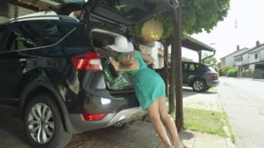 Mercek parlaması: Neşeli kadın onun Bagaj, onun Suv önyükleme sığdırmaya çalışır. Beyaz kız tüm bavulları bir arabaya sıkma problemleri. Aptal kadın turist onu tatil için overpacked.