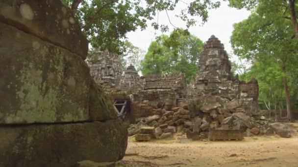 クローズアップ 静かなカンボジアの森の中で破壊された石の寺院の美しいショット 有名な仏教寺院の複合体の遺跡は 自然の中でゆっくりと衰退し 衰退しています 壮大なアンコールワットの建物 — ストック動画