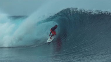 Slow Motion, Close Up: Sığ suda yatan arkadaşı onu izlerken büyük bir kristal berraklığında tüp dalga sürme genç sporcu. Fransız Polinezyası'nda muhteşem bir dalga sörf Aşırı atlet