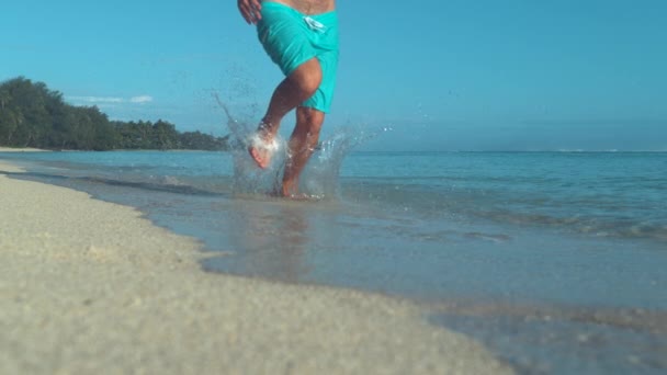 慢动作 低角度 无法辨认的年轻人赤脚跑下美丽的白色沙滩在夏天 活跃男性游客在假期慢跑在壮观的天堂岛上一个完美的阳光明媚的一天 — 图库视频影像