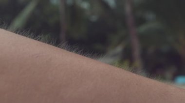 Close Up, Macro, Dof: Bilinmeyen yetişkin kişi bükülür ve tüylerini diken diken göstermek için kollarını çevirir. Genç dişi okyanustan gelen soğuk esintide titriyor. Kadın üşür ve titremeye başlar.