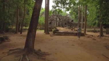 Tanınmayan genç kadın Kamboçya'da uzak bir ormanda inşa edilmiş çürüyen bir tapınak kompleksine girer. Ünlü Angkor Wat tapınaklarını keşfeden kadın gezgin. Dini kalıntılara doğru yürüyen kız.