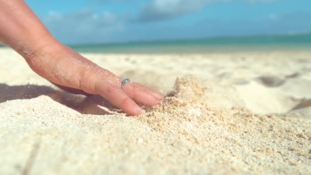 スローモーション クローズアップ Dof 認識できない若い女性は 熱い白い砂を通して彼女の穏やかな指を実行します 遊び心のある女の子は息をのむような熱帯のビーチでリラックスしながら 彼女の手で砂を散乱 — ストック動画