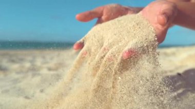 Slow Motion, Close Up: Bilinmeyen kadın turist boş egzotik plajda eğlenmek ve yumuşak kum ile oynuyor. Yaz tatilinde parmaklarının arasına kum silerek dinlenen kaygısız kadın.
