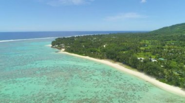 Hava: Muhteşem mercan resifi üzerinde uçan ve yemyeşil palmiye ağaçları ile çevrili lüks okyanus kıyısında tesisi doğru. Büyük uzak egzotik ada ve sıçrayan mavi okyanus dalgaları muhteşem çekim.