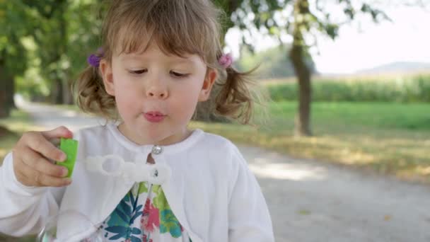 Slow Motion Portret Wesoła Dziewczyna Maluch Wieje Pęcherzyki Mydła Słoneczny — Wideo stockowe