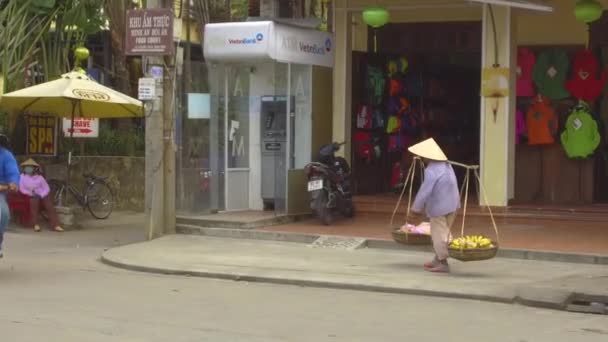 2017年3月 越南海安 老人头戴草帽 提着装满越南传统食品的篮子走在繁忙的街道上 不明身份的男街头摊贩 提着沉重的口粮篮 — 图库视频影像
