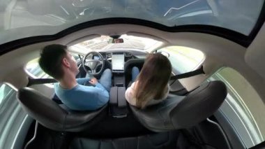 Tesla Autonomous Car, Mart 2018 - Close Up: Pervasız genç adam ve kadın yüksek teknoloji kendi kendine direksiyon araba dans. Harika bir otonom Tesla araba eğlenceli bir yol gezisi sırasında tasasız çift dans.