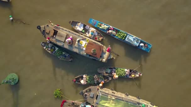 トップダウン ベトナムの濁った川の周りに浮かぶ彼らの木製のボートからビジネスを行う浮遊市場の商人 ベトナムの田舎の地元の人々は ボートから自分の農産物を販売しています — ストック動画