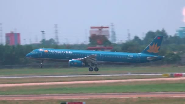 ハノイ空港 ベトナム 2017 晴れた日にハノイに着陸旅客機大きい青の映画のようなショット ベトナム航空の飛行機の着陸し 車輪の背後に煙の道を残す — ストック動画