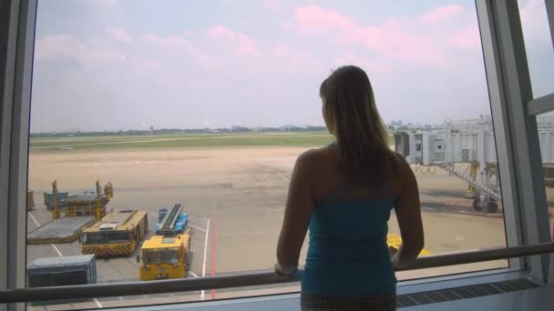 ハノイ空港 ベトナム 2017年3月 クローズアップ 展望デッキから空の滑走路を見て若い女性旅行者 ハノイ国際空港からのフライトを待っている白人女性 — ストック動画