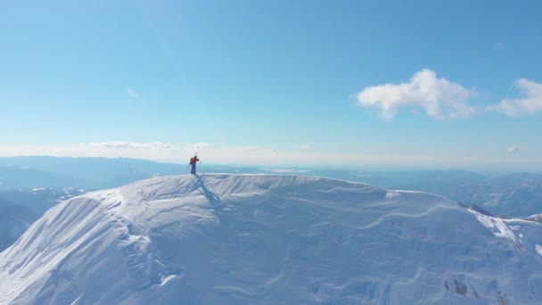 壮观的阳光明媚的山脉环绕着一个无法辨认的滑雪者 在滑雪前 在覆盖山坡的新鲜粉末雪中滑雪 拍摄到雄伟的大自然 美丽的冬季景观 — 图库视频影像