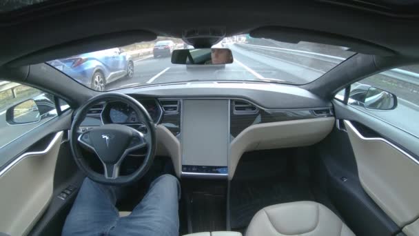 テスラ自動運転車 2018年3月 クローズアップ 自動運転車のラッシュアワー中に高速道路を運転する若者 忙しい朝 自動運転車で通勤する男性 革新的な輸送 — ストック動画