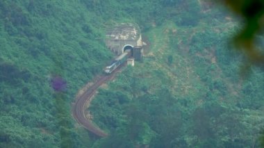 Hava: Uzun yük treni tünelden geliyor ve uzak ada kapsayan gür egzotik orman taşır. Nefes kesen Hai Van geçmek crossing tren. Muhteşem yeşil dağlar.