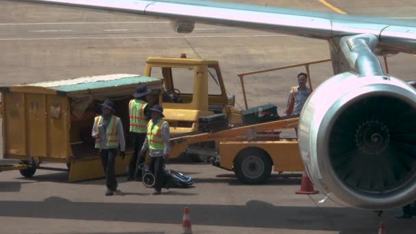 河内机场 2017年3月 地勤人员从飞机机身收集乘客的行李 机场员工将旅行包从传送带移到黄色卡车上 — 图库视频影像