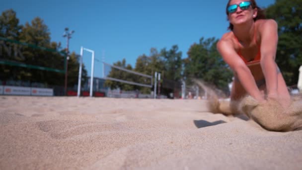 慢动作 女子排球运动员在夏季比赛中潜入一个点 适合打沙滩排球的白人女孩在试图触球的时候撞到了炽热的沙滩上 — 图库视频影像