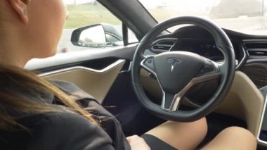 Özerk Tesla arabayı, Mart 2018 - yakın: yüksek teknoloji araba kendi kendine çalışmak için sakin bir sürücü zevk tanınmaz işkadını. Genç de otoyol düşürüyorlardı beyaz bir kadın giyinmiş.