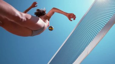 Slow Motion, Bottom Up, Close Up voleybol oynayan beyaz bir kadın açık mavi gökyüzünün altında topu ağlara fırlatıyor. Harika bir atletik kız vuruşu. Havaya atlayıp sayı yapıyor..