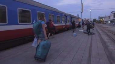 Hoi An, Vietnam, Şubat 2017: tanınmayan genç kadın platformu ve kalkış için bekleyen tren boyunca seyahat çantasını. Bir gecede trene binmeye Asya'da backpacking erkek.