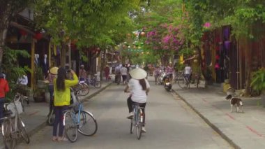 Hoi An, Vietnam, Mart 2017: Yerli halk ve turistler dolunay kutlaması öncesinde tarihi Asya kasabasının dekore edilmiş sokaklarında dolaşıyor. Geleneksel bir festival öncesi pastoral yol süslenmiş.