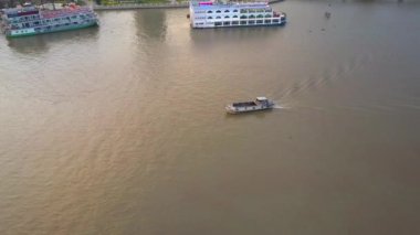 Hava: sakin kirli Nehri Vietnam boyunca seyir boş turist tekne. Küçük bir geleneksel ahşap gemi büyük geçmiş hareket hava serin görünümünden waterfront şehrin tarafından demirlemiş gemisi.