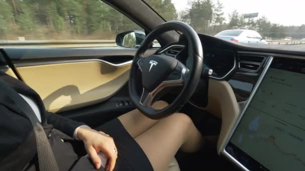 自主特斯拉汽车 2018年3月 未知的女商人驾驶她的自我转向特斯拉汽车工作 穿着优雅的女孩在没有方向盘的情况下沿着高速公路巡游 — 图库视频影像
