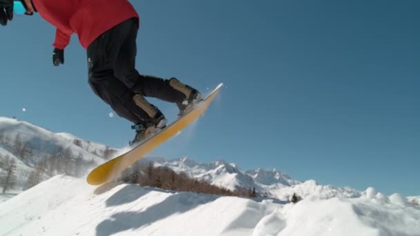 慢动作 赞成滑雪板的人骑到踢腿者的边缘 跳到空中做一个令人敬畏的把戏 田径男子滑雪板在空中滑行时抓住了他的滑板 — 图库视频影像