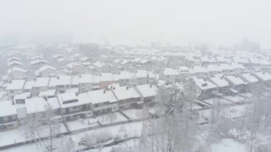 Hava: Pitoresk karlı bir günde bir banliyö mahallesinin boş sokakları üzerinde yüksek uçan. Taze karla kaplı beyaz çatıların serin havadan görünümü. Soğuk kış pastoral küçük kasaba.