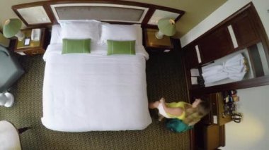 Yukarıdan aşağıya: Dinlendirici bir tatilde olan genç kadın otel odasındaki yatağın üzerine atlar. Oynak Kafkas kız Vietnam'da onu tatil süitinde büyük yatakta düşüyor. Kadın turist odasını almak için mutlu.